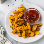Plate of crispy Air Fryer Butternut Squash Fries seasoned to perfection with a side of garlic thyme aioli.