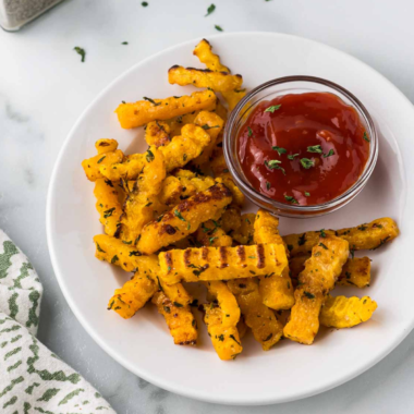 Plate of crispy Air Fryer Butternut Squash Fries seasoned to perfection with a side of garlic thyme aioli.