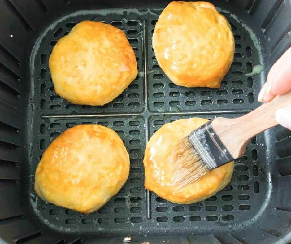 overhead process shot: brushing butter on biscuits in air fryer