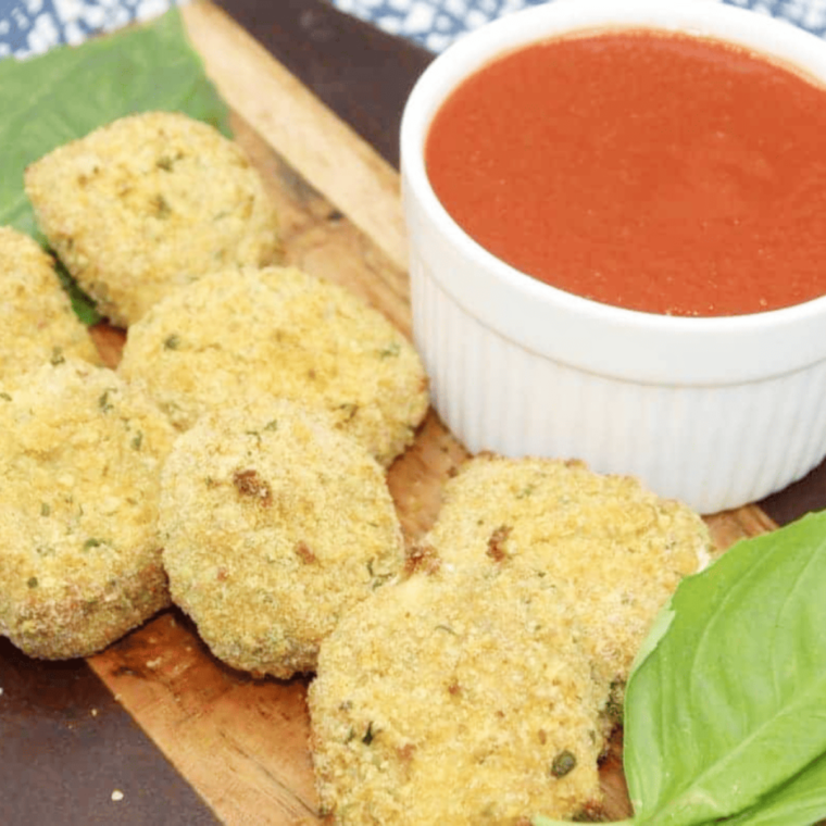 Plate of golden-brown Air Fryer Fried Goat Cheese Balls served with a dipping sauce.