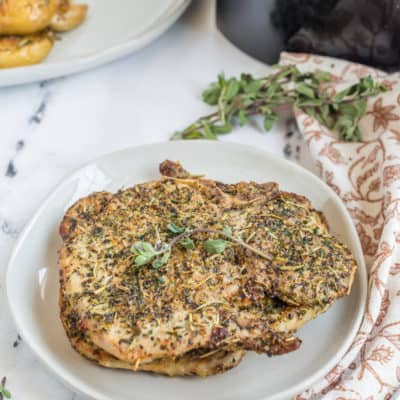 Is there anything better than a crispy, juicy pork chop? Now, you can make your favorite dish right at home with your air fryer! These frozen pork chops are easy to cook and taste delicious. Serve them with your favorite sides for a hearty meal. Air Fryer Frozen Pork Chops-I love a great air fryer pork chop dinner. Perfectly seasoned and air-fried up. Another day, and I totally forget to take the pork chops out of the freezer. Has this ever happened to you? Today, I’m going to know how to make the best Pork Chop Dinner from Air Fryer Frozen Pork Chops. These pork chops are perfectly seasoned and amazing, juicy and absolutely tender, and you would never think they came from frozen. Serve with an easy Instant Pot Spanish Rice Dish or Air Fryer Roasted Potatoes; you can have dinner (a full dinner) on the table within minutes. These will give you the best damn pork chops dinner. This will be one of the easiest air fryer recipes for the air fryer, making for a great and delicious batch of pork chops, with so much flavor! Ingredients Needed For Air Fryer Frozen Pork Chops If you're looking for an easy and healthy meal option, air fryer frozen pork chops are a good choice. In this post, we'll share the ingredients you'll need to make them. Plus, we'll give you some tips on how to cook them. This is an amazing recipe for busy weeknights! And you only need a handful of ingredients. Remember: The full recipe and ingredients are at the bottom of this post, in the printable recipe card. Pork Chops: Use either thin cut pork chops, boneless pork chops, bone-in pork chops, boneless chops, or thicker pork chops. Seasonings and Spices: Brown Sugar, Chili Powder, Smoked Paprika, Ground Cumin, Garlic Powder, Onion Powder, Thyme, Oregano, Ground Mustard, Salt, and Black Pepper. (This makes for a simple dry rub) Oil: Use olive oil, avocado oil, coconut oil, or grapeseed oil How To Cook Frozen Pork Chops In Air Fryer Step One: Place the frozen pork chops in a single layer, and set the temperature to 380 degrees F, cook for 5 to 8 minutes, or until the pork chops are defrosted. Step Two:: In a small bowl, add all of the dry rub ingredients, and then rub olive oil over the pork chops, and then rub the pork chops with the seasoning mix. Step Three: Return the seasoned pork chops to the air fryer basket, and cook for 12 to 16 minutes at 380 degrees F, remove the pork chops when the internal temperature reaches 145 degrees f when checked with an instant read thermometer. Step Four: Remove and let sit for 3-5 minutes, before serving. Tips For Cooking Frozen Pork Chops In The Air Fryer . If you're looking for a quick and easy way to cook frozen pork chops, the air fryer is the appliance for you. With just a few simple tips, you can have perfectly cooked pork chops in no time at all. Keep reading to learn how to make the most of your air fryer! More Flavor: Try marinating the frozen pork chops before cooking for added flavor. Crowding: Remember not to crowd the air fryer basket, as this can hinder even cooking They should be placed into the air fryer basket in a single layer, leaving space around the pork chops, which will help the frozen pork chops cook on all sides. Timing: Since all air fryers are different, and the thickness of the pork chop will affect the cooking time,t eh best way to determine if the frozen pork chops are done, is to use a meat thermometer to check the thickest part, of the pork steak, when the internal temperature reads 145 degrees f, you can safely remove the pork chop. What Kind of Pork Chops Can I Use? When it comes to pork chops, you have the option of using boneless or bone-in cuts. Boneless chops are easier to eat and cook evenly, but some argue that bone-in chops have more flavor. Thickness also plays a role in cooking time and how well the pork stays juicy. Generally, a thicker chop should be cooked with slower, indirect heat to ensure proper cooking without drying out the meat. You can use boneless pork chops, bone-in pork chops, thin pork chops, pork tenderloin, or pork loin, or any frozen chops will work! Whatever type or thickness you choose, make sure your pork is always cooked to an internal temperature of 145 degrees Fahrenheit for safety. Experiment with different combinations to find your perfect pork chop! How To Know When The Frozen Pork Chops Are Done Cooking When it comes to pork chops, you have the option of using boneless or bone-in cuts. Boneless chops are easier to eat and cook evenly, but some argue that bone-in chops have more flavor. Thickness also plays a role in cooking time and how well the pork stays juicy. Generally, a thicker chop should be cooked with slower, indirect heat to ensure proper cooking without drying out the meat. Whatever type or thickness you choose, make sure your pork is always cooked to an internal temperature of 145 degrees Fahrenheit for safety. Experiment with different combinations to find your perfect pork chop! To check the temperature of your pork chops, use a digital meat thermometer and insert it into the thickest part of the meat, avoiding any bones. As long as the internal temperature of the pork chops reads 145 degrees Fahrenheit or above, your pork chops are ready to be enjoyed! Another way to check for doneness is by pressing on the chop with a fork or tongs. It should feel firm, but still slightly springy. When in doubt, err on the side of caution and cook until the recommended internal temperature is reached. Undercooked pork can carry harmful bacteria and cause foodborne illness. Enjoy your perfectly cooked pork chops with some delicious sides, for an easy weeknight meal. Seasonings For Pork Chops There are many options for seasoning pork chops, including dry rubs and breading. For a dry rub, some popular seasonings to use are garlic powder, cumin, smoked paprika, and brown sugar. Using seasonings is a great way to make a simple low carb air fryer dinner! If you prefer breading your pork chops, try using a mixture of bread crumbs and grated Parmesan cheese for a delicious crust. Don't be afraid to experiment with different herbs and spices to find your perfect flavor combination. Regardless of which method you choose, always remember to generously season both sides of the meat before cooking. How To Store Leftover Pork Chops Once you have finished cooking and enjoying your delicious pork chops, it is important to properly store any leftovers. First, let the meat cool completely, to room temperature, before transferring it into an airtight container or plastic bag. Place the container in the refrigerator, where it will stay fresh for 3-4 days. How To Reheat Pork Chops In Air Fryer If you have any leftover pork chops, a great way to reheat them is by using your air fryer! 1. Preheat the air fryer to 375 degrees Fahrenheit, and spray your air fryer basket with cooking spray. 2. Place pork chops in the air fryer basket, making sure they aren't overlapping or stacked on top of each other. 3. Cook for 8-10 minutes, flipping the chops halfway through, until they reach an internal temperature of 145 degrees Fahrenheit. 4. Serve hot and enjoy! Optional: add a sprinkle of your favorite seasoning before cooking for added flavor. Best Sides For Pork Chops When it comes to choosing a side dish for your pork chops, broccoli, rice, and green beans are all great options. Broccoli pairs well with the savory flavor of pork chops and adds a pop of color to your plate. Rice is a versatile choice that can be prepared in many different ways, from simple white rice to flavorful Spanish or Cajun-style seasoning mixes. Green beans add a fresh and crunchy element to your meal. Whichever option you choose, these sides complement the juicy deliciousness of pork chops perfectly. Give them a try next time you cook up some pork chops for dinner!