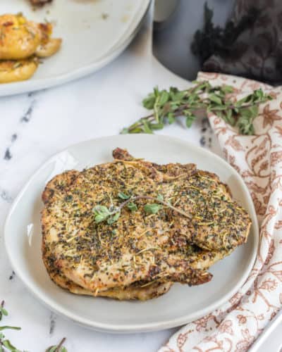 Is there anything better than a crispy, juicy pork chop? Now, you can make your favorite dish right at home with your air fryer! These frozen pork chops are easy to cook and taste delicious. Serve them with your favorite sides for a hearty meal. Air Fryer Frozen Pork Chops-I love a great air fryer pork chop dinner. Perfectly seasoned and air-fried up. Another day, and I totally forget to take the pork chops out of the freezer. Has this ever happened to you? Today, I’m going to know how to make the best Pork Chop Dinner from Air Fryer Frozen Pork Chops. These pork chops are perfectly seasoned and amazing, juicy and absolutely tender, and you would never think they came from frozen. Serve with an easy Instant Pot Spanish Rice Dish or Air Fryer Roasted Potatoes; you can have dinner (a full dinner) on the table within minutes. These will give you the best damn pork chops dinner. This will be one of the easiest air fryer recipes for the air fryer, making for a great and delicious batch of pork chops, with so much flavor! Ingredients Needed For Air Fryer Frozen Pork Chops If you're looking for an easy and healthy meal option, air fryer frozen pork chops are a good choice. In this post, we'll share the ingredients you'll need to make them. Plus, we'll give you some tips on how to cook them. This is an amazing recipe for busy weeknights! And you only need a handful of ingredients. Remember: The full recipe and ingredients are at the bottom of this post, in the printable recipe card. Pork Chops: Use either thin cut pork chops, boneless pork chops, bone-in pork chops, boneless chops, or thicker pork chops. Seasonings and Spices: Brown Sugar, Chili Powder, Smoked Paprika, Ground Cumin, Garlic Powder, Onion Powder, Thyme, Oregano, Ground Mustard, Salt, and Black Pepper. (This makes for a simple dry rub) Oil: Use olive oil, avocado oil, coconut oil, or grapeseed oil How To Cook Frozen Pork Chops In Air Fryer Step One: Place the frozen pork chops in a single layer, and set the temperature to 380 degrees F, cook for 5 to 8 minutes, or until the pork chops are defrosted. Step Two:: In a small bowl, add all of the dry rub ingredients, and then rub olive oil over the pork chops, and then rub the pork chops with the seasoning mix. Step Three: Return the seasoned pork chops to the air fryer basket, and cook for 12 to 16 minutes at 380 degrees F, remove the pork chops when the internal temperature reaches 145 degrees f when checked with an instant read thermometer. Step Four: Remove and let sit for 3-5 minutes, before serving. Tips For Cooking Frozen Pork Chops In The Air Fryer . If you're looking for a quick and easy way to cook frozen pork chops, the air fryer is the appliance for you. With just a few simple tips, you can have perfectly cooked pork chops in no time at all. Keep reading to learn how to make the most of your air fryer! More Flavor: Try marinating the frozen pork chops before cooking for added flavor. Crowding: Remember not to crowd the air fryer basket, as this can hinder even cooking They should be placed into the air fryer basket in a single layer, leaving space around the pork chops, which will help the frozen pork chops cook on all sides. Timing: Since all air fryers are different, and the thickness of the pork chop will affect the cooking time,t eh best way to determine if the frozen pork chops are done, is to use a meat thermometer to check the thickest part, of the pork steak, when the internal temperature reads 145 degrees f, you can safely remove the pork chop. What Kind of Pork Chops Can I Use? When it comes to pork chops, you have the option of using boneless or bone-in cuts. Boneless chops are easier to eat and cook evenly, but some argue that bone-in chops have more flavor. Thickness also plays a role in cooking time and how well the pork stays juicy. Generally, a thicker chop should be cooked with slower, indirect heat to ensure proper cooking without drying out the meat. You can use boneless pork chops, bone-in pork chops, thin pork chops, pork tenderloin, or pork loin, or any frozen chops will work! Whatever type or thickness you choose, make sure your pork is always cooked to an internal temperature of 145 degrees Fahrenheit for safety. Experiment with different combinations to find your perfect pork chop! How To Know When The Frozen Pork Chops Are Done Cooking When it comes to pork chops, you have the option of using boneless or bone-in cuts. Boneless chops are easier to eat and cook evenly, but some argue that bone-in chops have more flavor. Thickness also plays a role in cooking time and how well the pork stays juicy. Generally, a thicker chop should be cooked with slower, indirect heat to ensure proper cooking without drying out the meat. Whatever type or thickness you choose, make sure your pork is always cooked to an internal temperature of 145 degrees Fahrenheit for safety. Experiment with different combinations to find your perfect pork chop! To check the temperature of your pork chops, use a digital meat thermometer and insert it into the thickest part of the meat, avoiding any bones. As long as the internal temperature of the pork chops reads 145 degrees Fahrenheit or above, your pork chops are ready to be enjoyed! Another way to check for doneness is by pressing on the chop with a fork or tongs. It should feel firm, but still slightly springy. When in doubt, err on the side of caution and cook until the recommended internal temperature is reached. Undercooked pork can carry harmful bacteria and cause foodborne illness. Enjoy your perfectly cooked pork chops with some delicious sides, for an easy weeknight meal. Seasonings For Pork Chops There are many options for seasoning pork chops, including dry rubs and breading. For a dry rub, some popular seasonings to use are garlic powder, cumin, smoked paprika, and brown sugar. Using seasonings is a great way to make a simple low carb air fryer dinner! If you prefer breading your pork chops, try using a mixture of bread crumbs and grated Parmesan cheese for a delicious crust. Don't be afraid to experiment with different herbs and spices to find your perfect flavor combination. Regardless of which method you choose, always remember to generously season both sides of the meat before cooking. How To Store Leftover Pork Chops Once you have finished cooking and enjoying your delicious pork chops, it is important to properly store any leftovers. First, let the meat cool completely, to room temperature, before transferring it into an airtight container or plastic bag. Place the container in the refrigerator, where it will stay fresh for 3-4 days. How To Reheat Pork Chops In Air Fryer If you have any leftover pork chops, a great way to reheat them is by using your air fryer! 1. Preheat the air fryer to 375 degrees Fahrenheit, and spray your air fryer basket with cooking spray. 2. Place pork chops in the air fryer basket, making sure they aren't overlapping or stacked on top of each other. 3. Cook for 8-10 minutes, flipping the chops halfway through, until they reach an internal temperature of 145 degrees Fahrenheit. 4. Serve hot and enjoy! Optional: add a sprinkle of your favorite seasoning before cooking for added flavor. Best Sides For Pork Chops When it comes to choosing a side dish for your pork chops, broccoli, rice, and green beans are all great options. Broccoli pairs well with the savory flavor of pork chops and adds a pop of color to your plate. Rice is a versatile choice that can be prepared in many different ways, from simple white rice to flavorful Spanish or Cajun-style seasoning mixes. Green beans add a fresh and crunchy element to your meal. Whichever option you choose, these sides complement the juicy deliciousness of pork chops perfectly. Give them a try next time you cook up some pork chops for dinner!