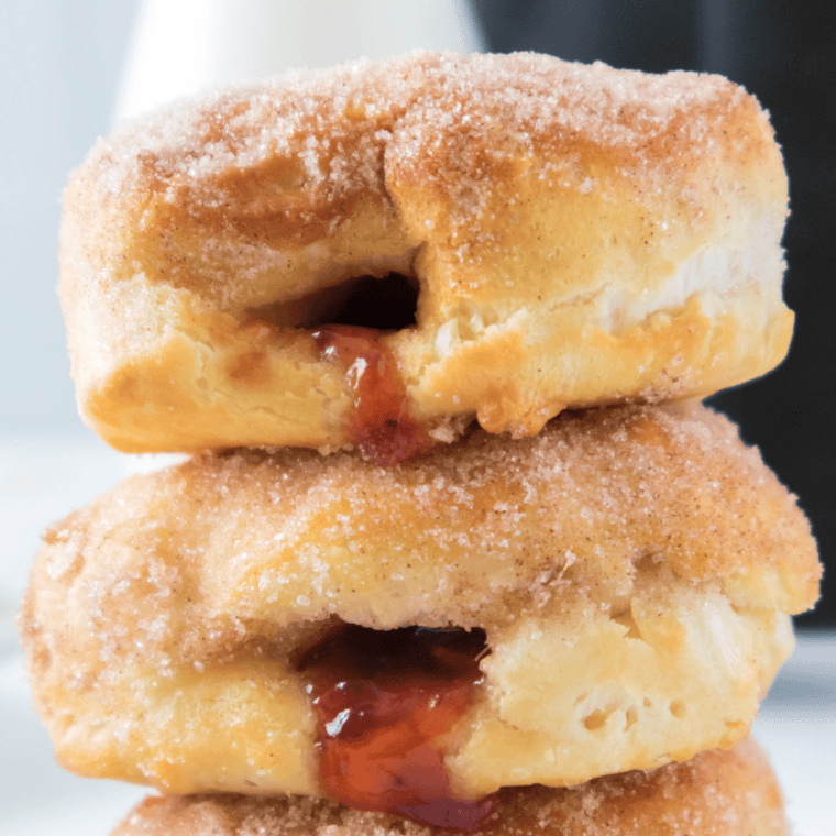 Close-up of a strawberry-filled air fryer jelly donut split open to show the jam