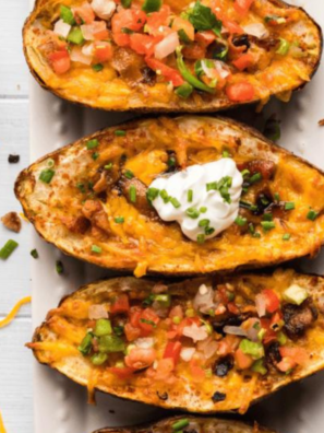 Delicious Air Fryer Loaded Potato Skins topped with cheese, bacon, and green onions.