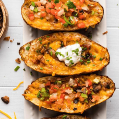 Delicious Air Fryer Loaded Potato Skins topped with cheese, bacon, and green onions.