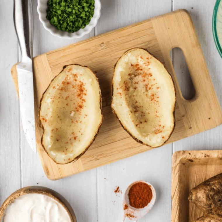 Scooping out the middle of the potatoes, for the filling.