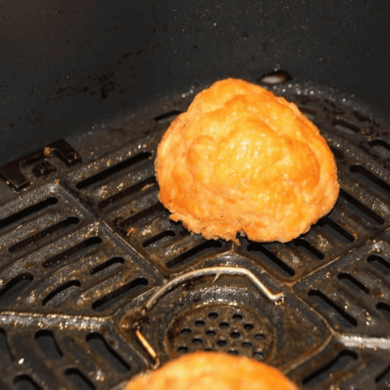 Golden brown lobster cakes finished cooking in the air fryer basket