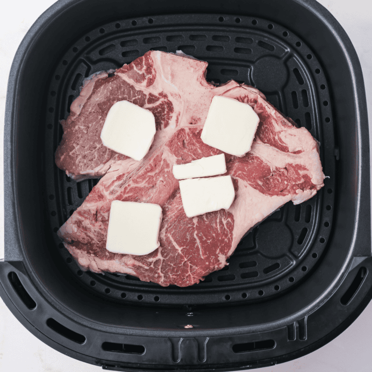 Porterhouse steaks seasoned on both sides with kosher salt and cracked black pepper.