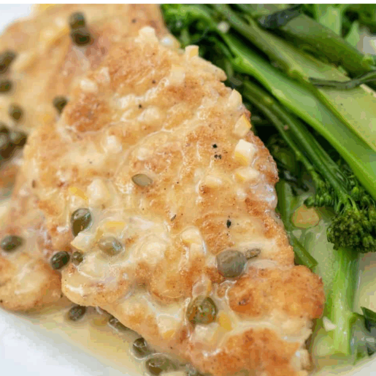 Carrabba’s Chicken Piccata served with lemon-caper sauce and fresh parsley on a white plate.