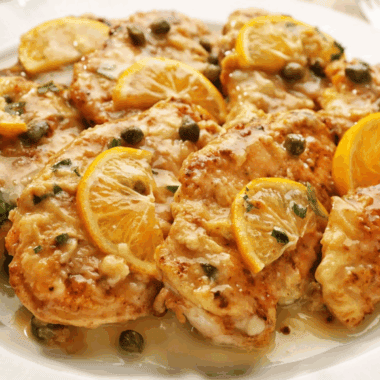 Homemade Carrabba’s Chicken Piccata with lemon-caper sauce served on a dinner plate.