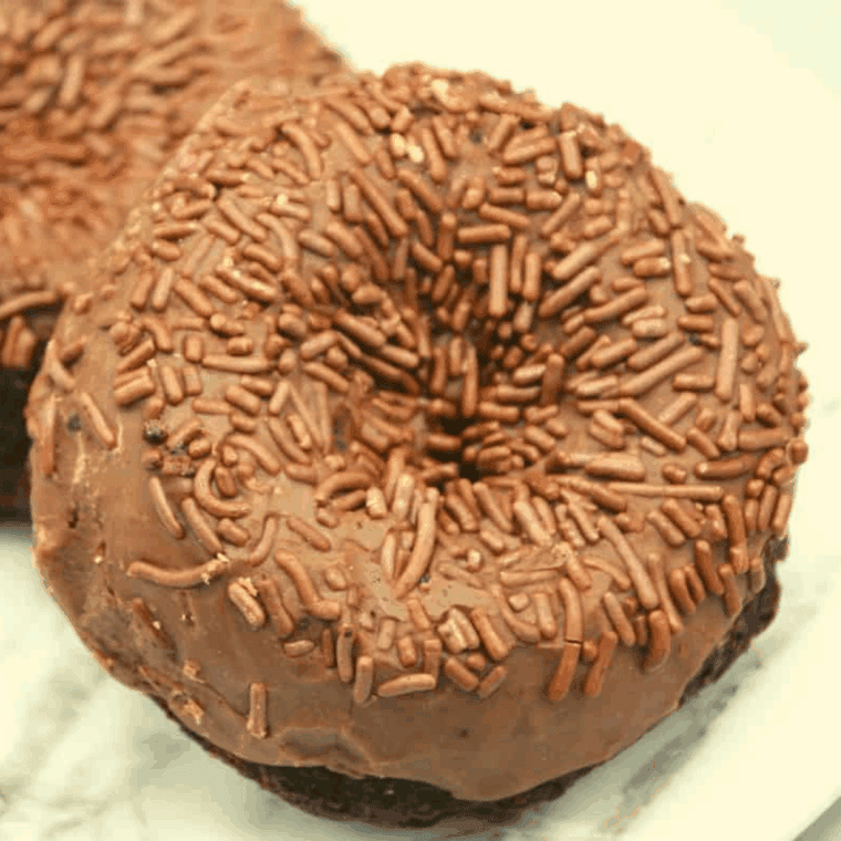 Homemade Tim Hortons-style chocolate glazed donuts on a cooling rack with glossy chocolate coating.
