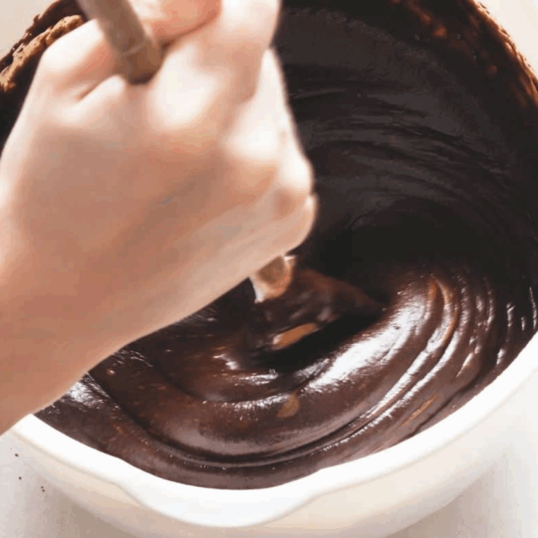 Mixing butter, sugars, egg, vanilla, and sour cream in one bowl, with flour, cocoa, and leavening ingredients combined in another.