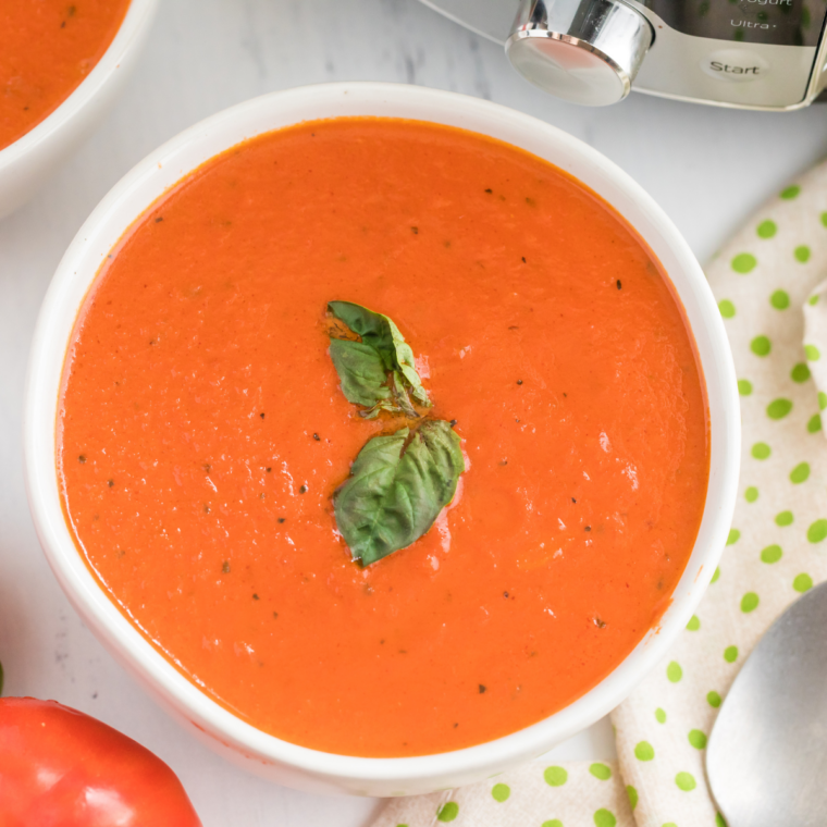 Bowl of creamy copycat Nordstrom tomato basil soup garnished with fresh basil leaves