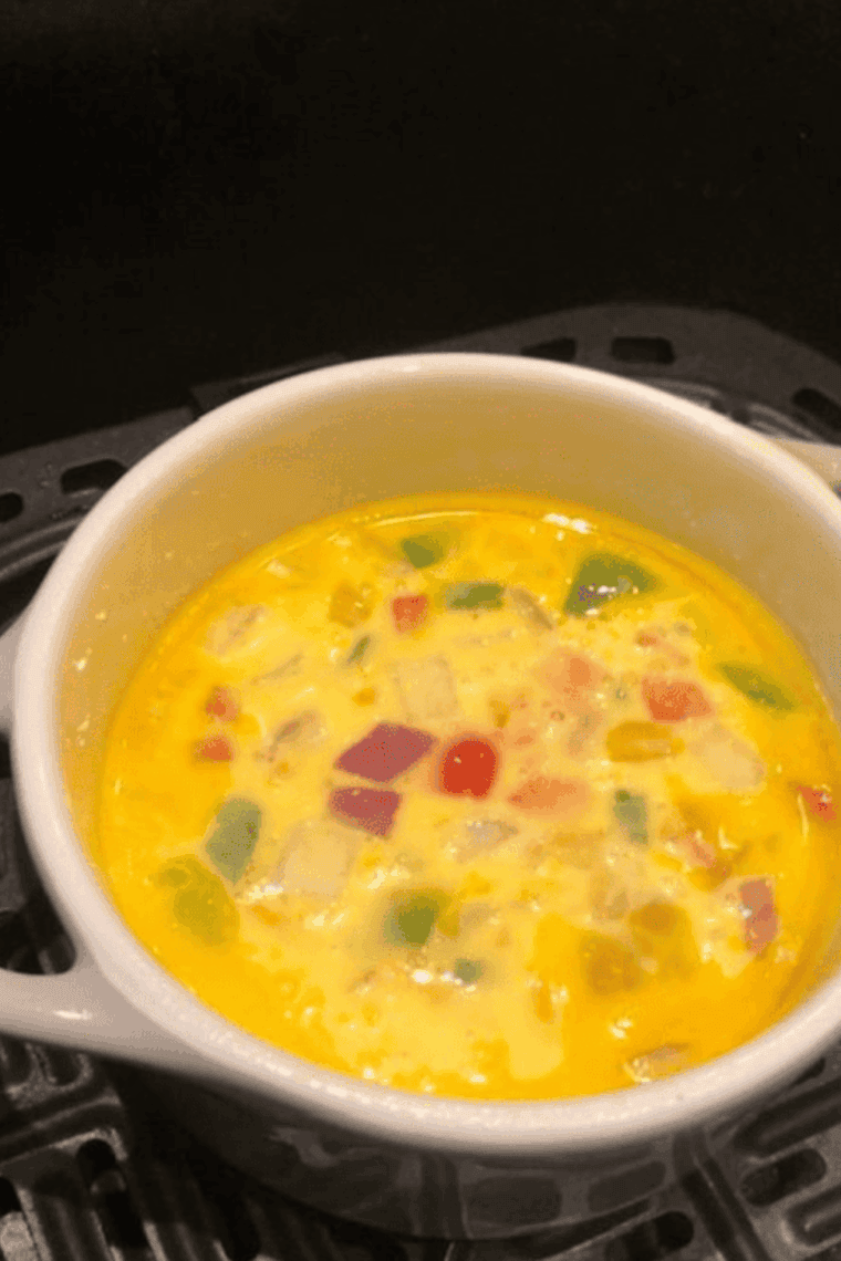 Fluffy air fryer vegetable omelet with colorful peppers, spinach, and melted cheese.