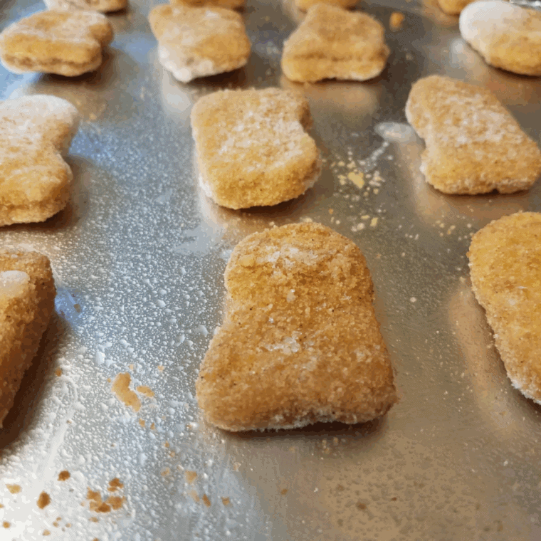 Crispy reheated McDonald’s Chicken McNuggets in air fryer basket with dipping sauce nearby