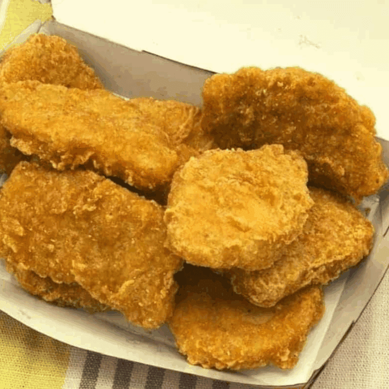 Air fryer basket filled with reheated McDonald’s Chicken McNuggets, golden and crispy