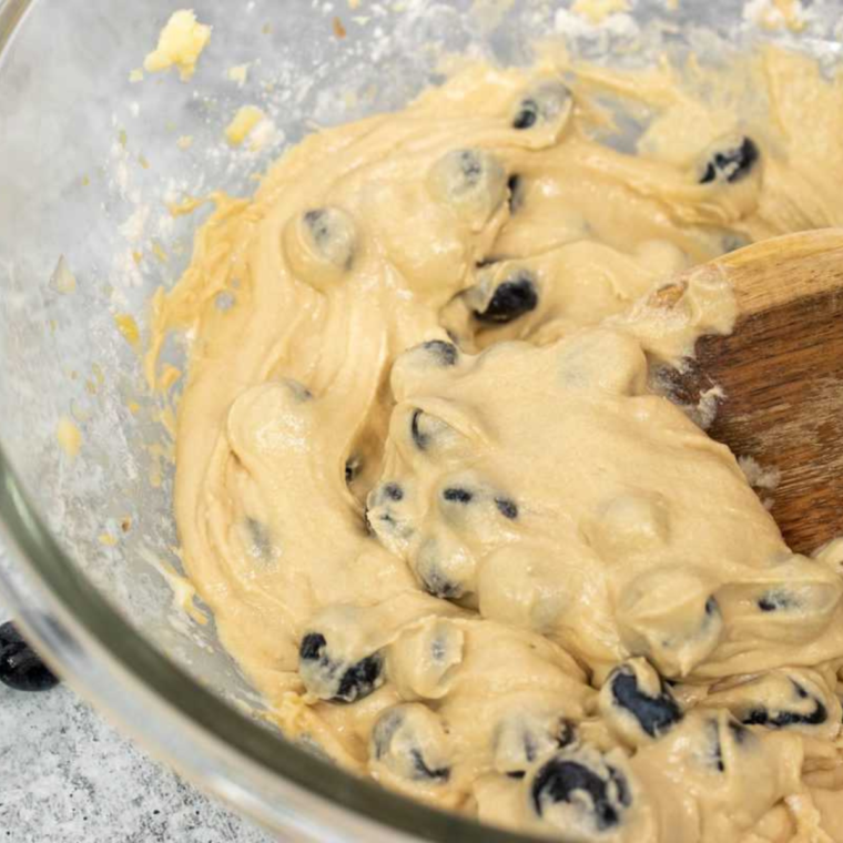 Mixing bowl with ingredients for Instant Pot Blueberry Muffins, including flour, sugar, and blueberries.