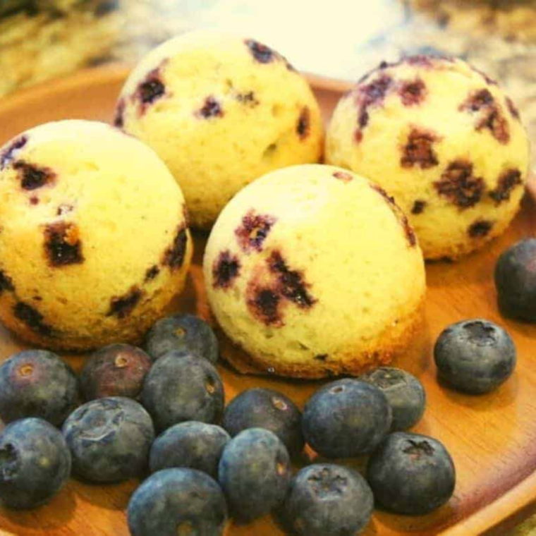 Instant Pot Blueberry Muffins fresh out of the Instant Pot, with a golden brown top and visible blueberry chunks.