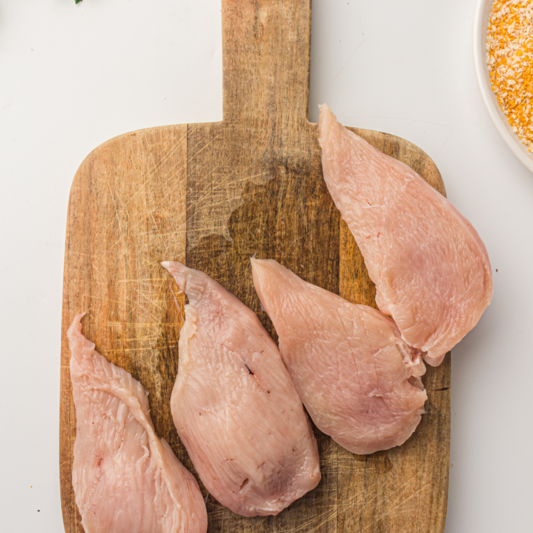 Sliced chicken on the wooden cutting board.