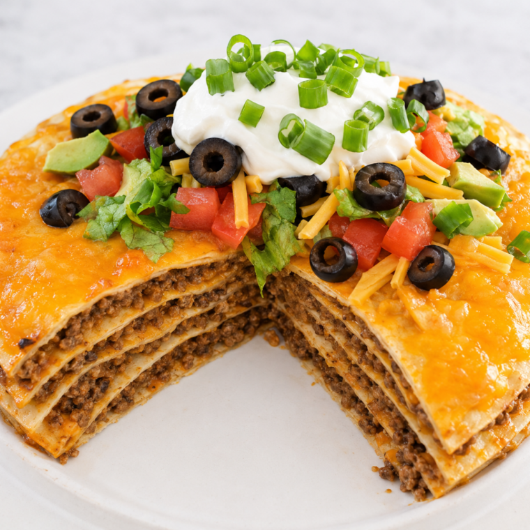 Air fryer taco pie in a springform pan topped with melted cheese and fresh toppings