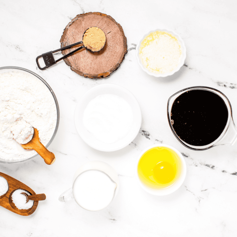 Ingredients for air fryer 7-Up cake on a table: yellow cake mix, lemon pudding, 7-Up, eggs, and vegetable oil