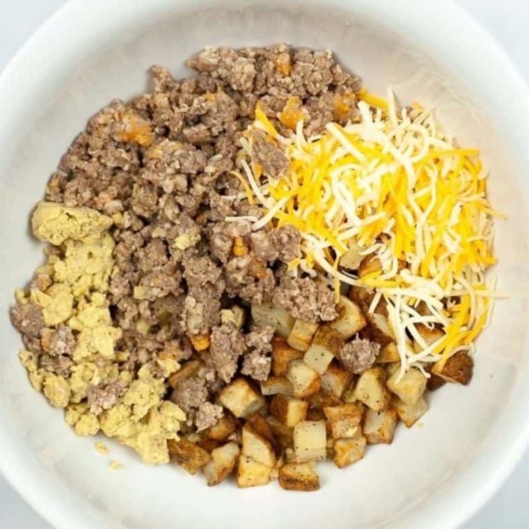 Ingredients laid out for Air Fryer Breakfast Chimichangas, including tortillas, scrambled eggs, diced ham, and potatoes.