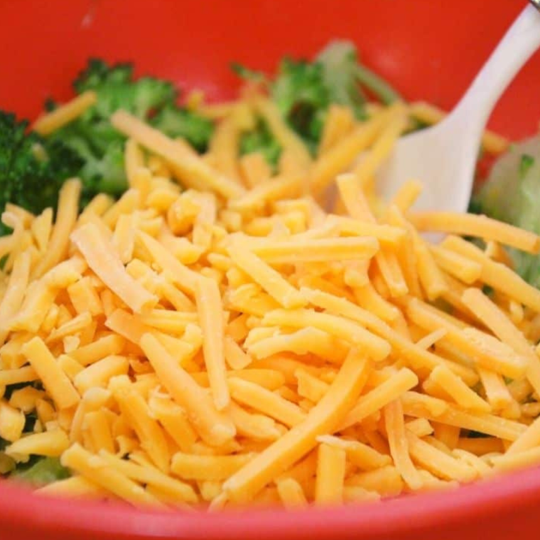 Mixing the cheese into the broccoli, mix well, to coat the broccoli.