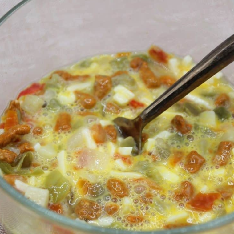 Mixing ingredients for Air Fryer Chorizo Egg Muffins in a bowl.