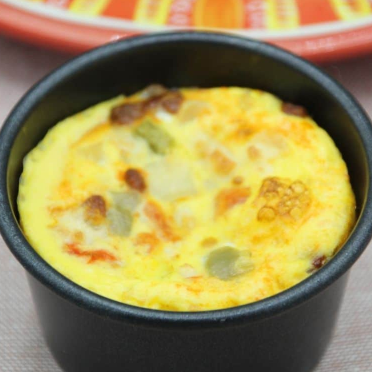 Air Fryer Chorizo Egg Muffins being sliced to reveal fluffy texture inside.