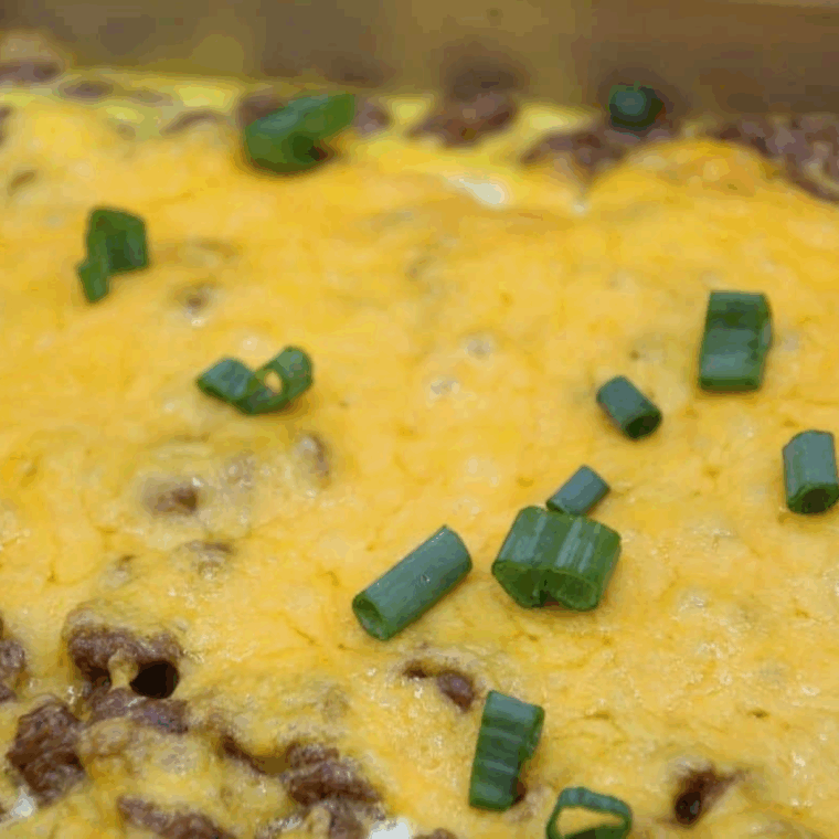 Golden-brown crescent roll breakfast casserole baked in the air fryer, filled with eggs, sausage, and melted cheese.