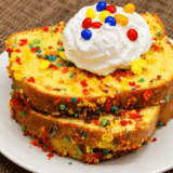 Air Fryer Fruity Pebbles French Toast served on a plate with a swirl of whipped cream