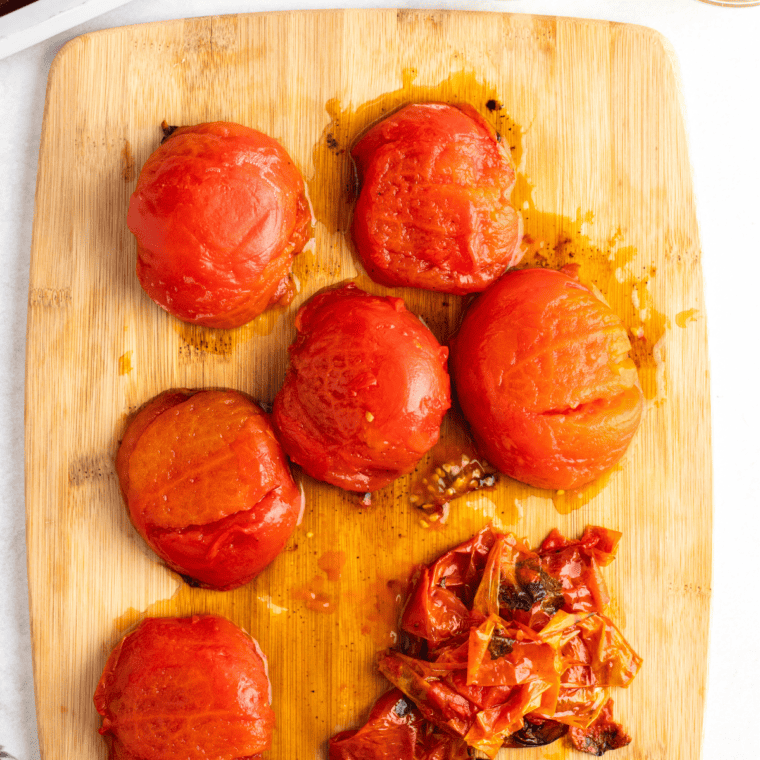 overhead: peeling tomatoes on a cutting board for air fryer salsa recipe