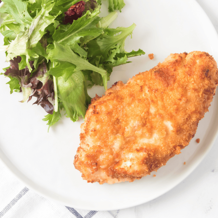 Finished air fryer shake and bake chicken resting on a plate before serving