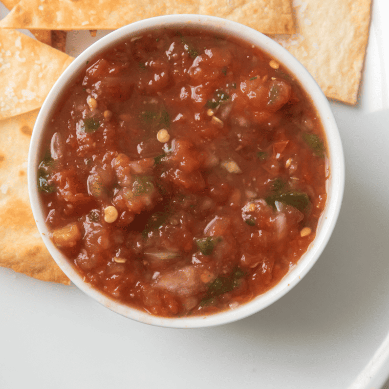 overhead closeup: a small bowl of air fryer salsa with tortilla chips to the side