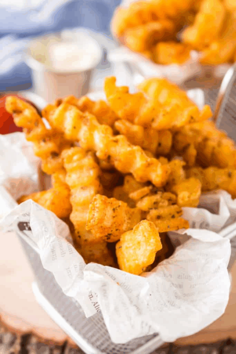 Bowl of homemade Bojangles-style French fry seasoning with golden crispy fries in the background