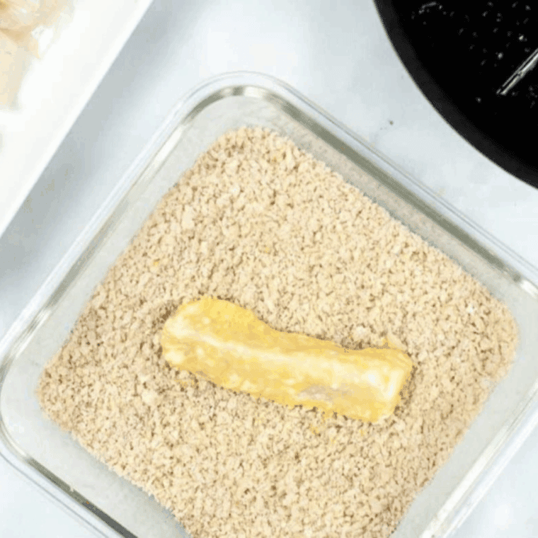 Place the fish sticks in the breadcrumb mixture.