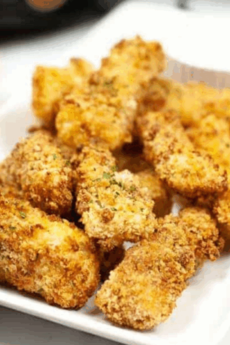 Plate of crispy, golden Captain D’s style fish sticks served with dipping sauce.
