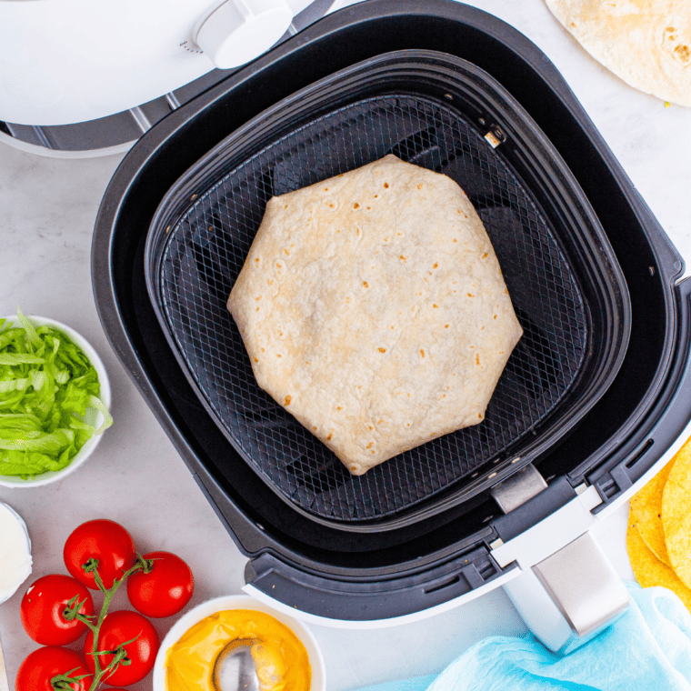 overhead process shot: folded crunchwrap supreme placed seam side down in air fryer