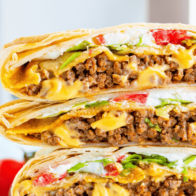 closeup: homemade crunchwrap supreme cut in half and stacked so fillings are showing