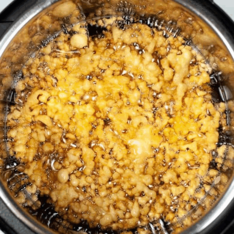 Fully cooked funnel cake in the air fryer basket.