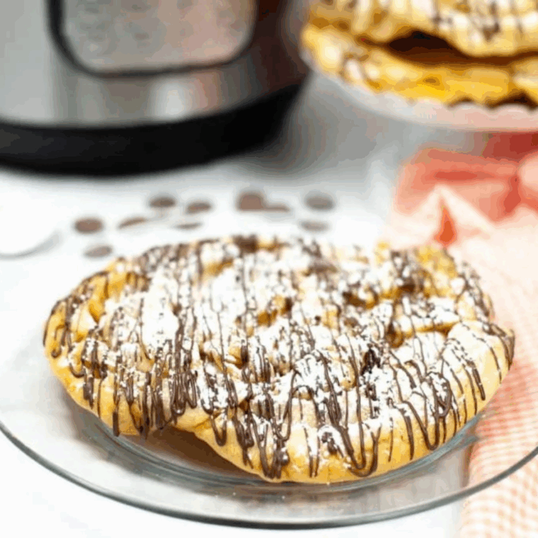 Golden, crispy Instant Pot Funnel Cakes dusted with powdered sugar, ready to enjoy as a carnival-style dessert.