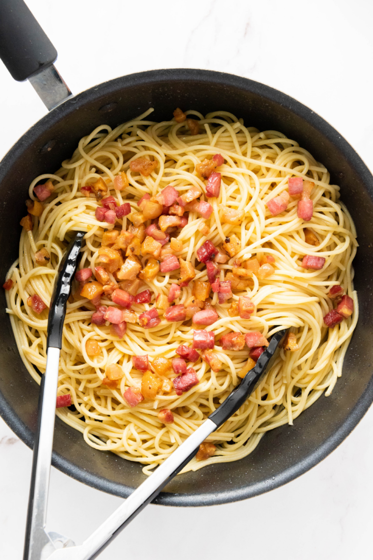 Combine pasta and bacon: Tossing hot drained spaghetti with crispy bacon and saut&eacute;ed garlic in skillet