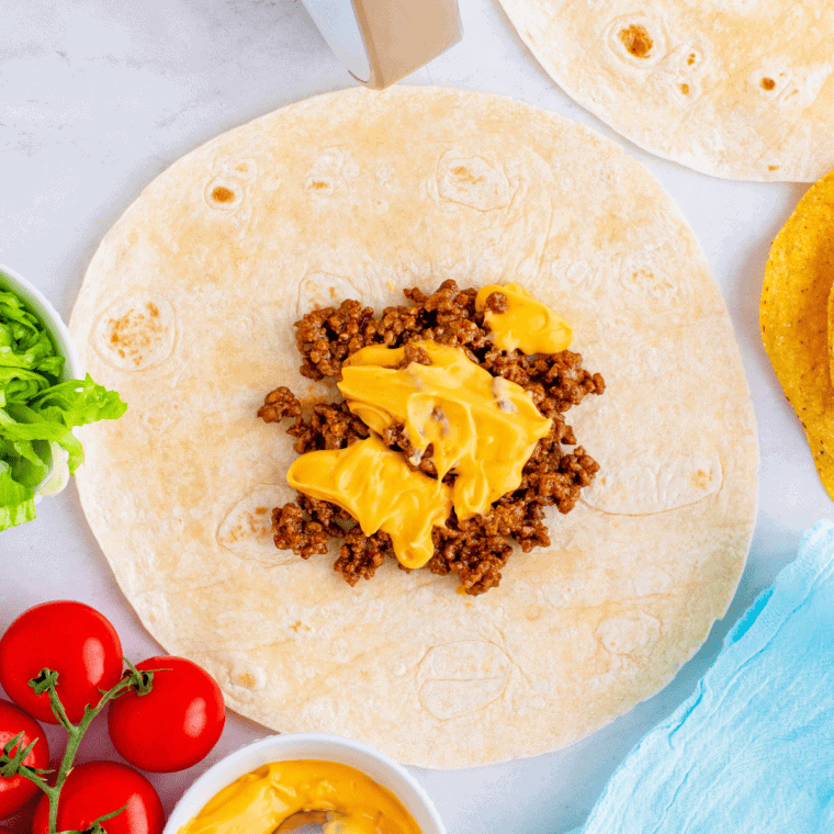 overhead process shot: ground beef and nacho cheese added to large tortilla