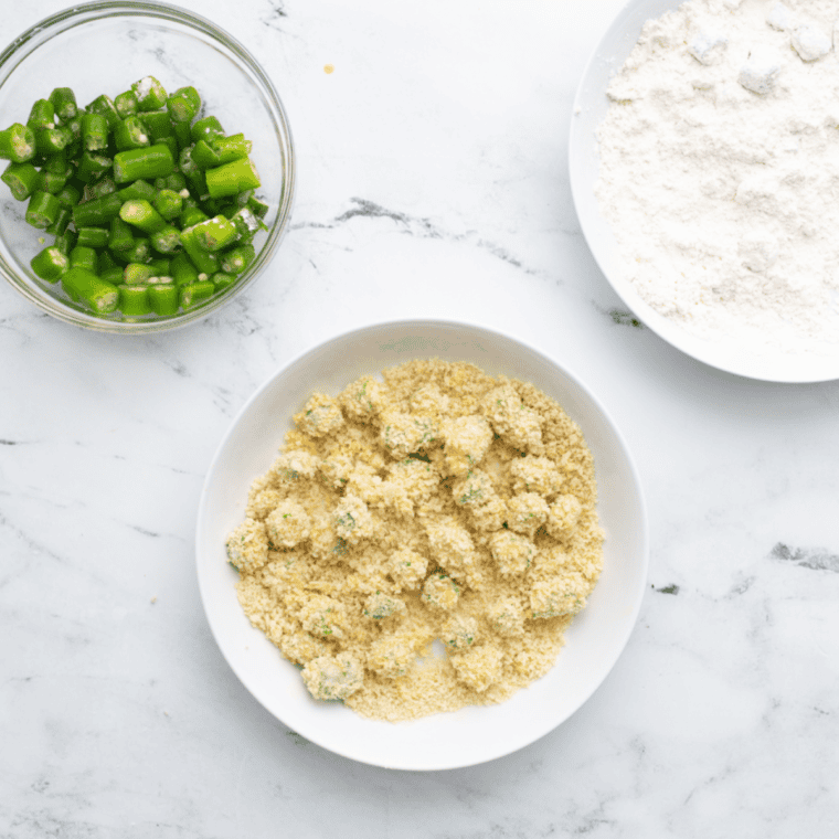 Coating diced okra in flour, egg wash, and breadcrumbs for breading.