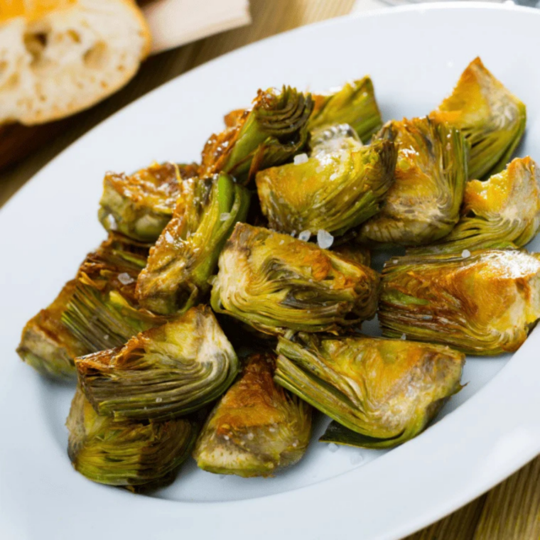 Air-fried artichoke hearts served on a plate with garlic aioli and fresh lemon
