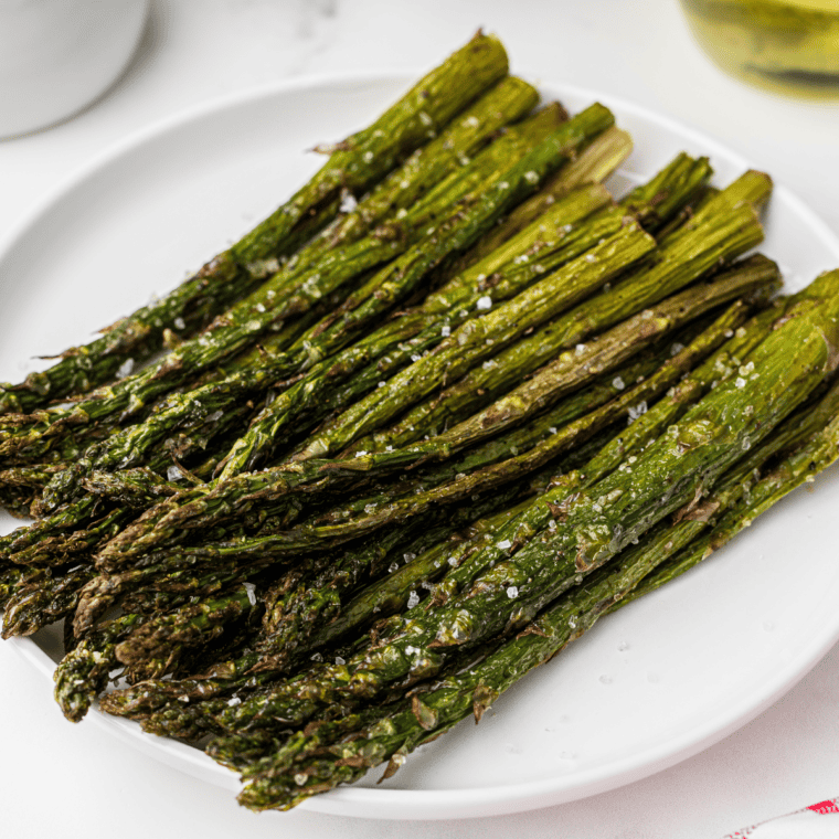 Air fryer basket filled with crispy cooked frozen asparagus.