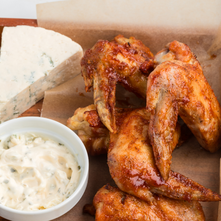 Close-up of crispy air fryer chicken wings tossed in honey BBQ sauce.