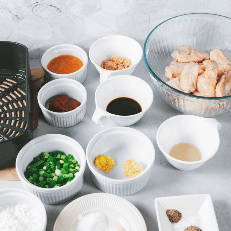 Ingredients for air fryer Jack Daniel's wings including chicken wings, baking powder, spices, and whiskey sauce