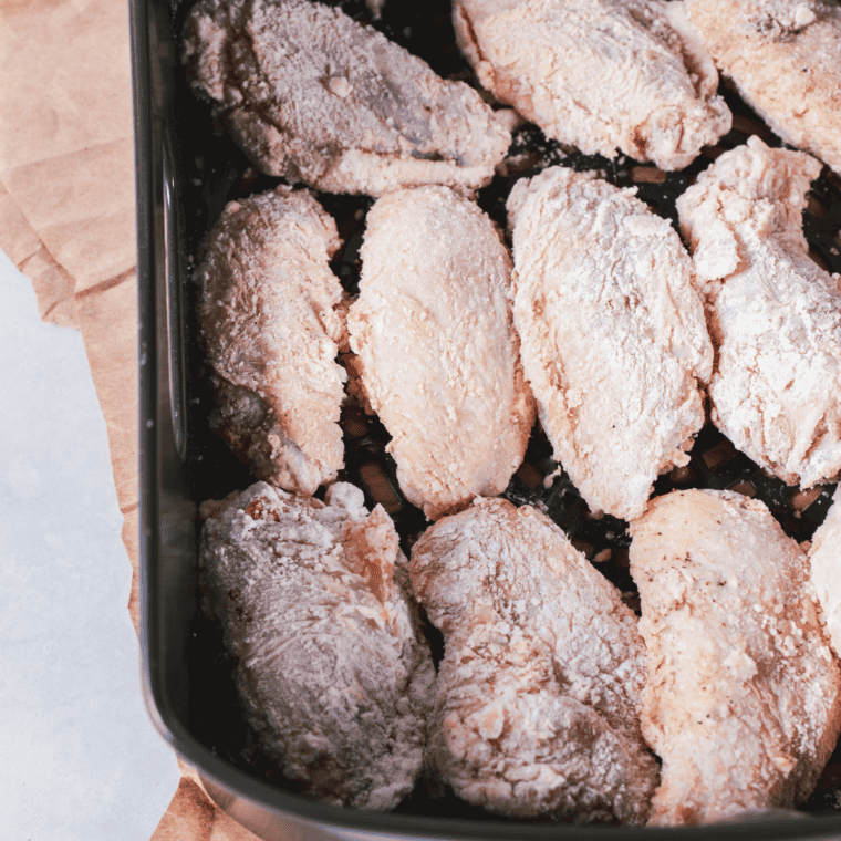 Seasoned chicken wings arranged in a single layer in the air fryer basket