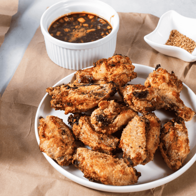 Crispy golden chicken wings in the air fryer basket after cooking